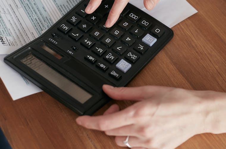 Persona joven mirando su teléfono con expresión de confianza, revisando su puntaje de crédito